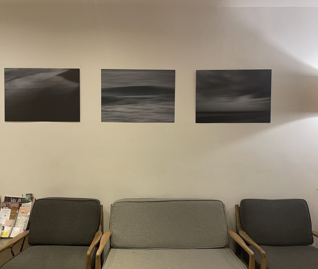 Deuxième salle d'attente NeuroLaser, canapé gris et triptyque marine